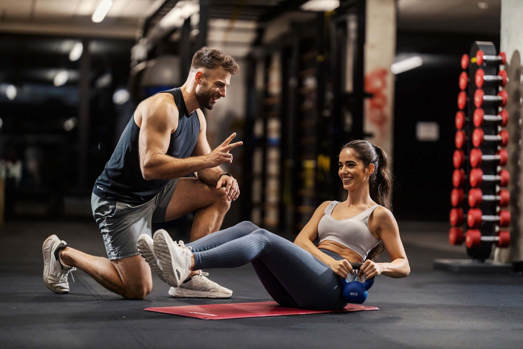 Trainer with female client doing kettlebell workout